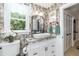 Bright bathroom featuring elegant fixtures, stylish mirror, and floral wallpaper at 7216 Rabbit Run, Wake Forest, NC 27587
