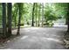 Spacious gravel driveway leading to a charming home and two-car garage, nestled among lush trees at 7216 Rabbit Run, Wake Forest, NC 27587