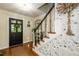 Stylish entryway featuring a dark door, floral wallpaper, and elegant staircase with decorative spindles at 7216 Rabbit Run, Wake Forest, NC 27587