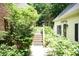 View of a home's walkway leading to a charming backyard with lush greenery and a pool in the background at 7216 Rabbit Run, Wake Forest, NC 27587