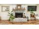 Close-up of living room fireplace with whitewashed brick, decorative mantel, and stylish accents at 7216 Rabbit Run, Wake Forest, NC 27587