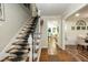 Inviting foyer with hardwood floors, decorative stair runner, and a glimpse into adjoining living spaces at 7216 Rabbit Run, Wake Forest, NC 27587