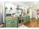 Well-lit kitchen includes stainless appliances, green cabinets, wood counters, and decorative shelving at 7216 Rabbit Run, Wake Forest, NC 27587