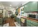 Sun-filled kitchen with wood counters, green cabinets, stainless steel appliances, and view of a garden area at 7216 Rabbit Run, Wake Forest, NC 27587