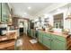 Bright kitchen features wood counters, stainless steel appliances, green cabinets, farmhouse sink, and brick accent wall at 7216 Rabbit Run, Wake Forest, NC 27587
