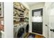 Convenient laundry room with modern washer and dryer, decorative wallpaper, and storage shelves at 7216 Rabbit Run, Wake Forest, NC 27587