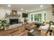 Cozy living room with a brick fireplace, large window, and comfortable green sectional sofa at 7216 Rabbit Run, Wake Forest, NC 27587