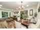 Open concept living and dining area featuring a large window, green sofa, and stylish decor elements at 7216 Rabbit Run, Wake Forest, NC 27587