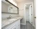 Bathroom featuring a stone countertop, wooden framed mirror, and access to an additional room at 747 Weathergreen Dr, Raleigh, NC 27615
