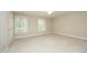 Bright and airy bedroom with neutral carpet, two windows, and a door at 747 Weathergreen Dr, Raleigh, NC 27615