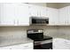 Modern kitchen with stainless steel oven and microwave against white cabinets and granite countertops at 747 Weathergreen Dr, Raleigh, NC 27615