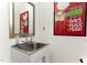 Cozy powder room with an undermount sink, framed mirror and framed poster on the wall at 7648 Winners Edge St, Raleigh, NC 27617