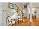 Foyer view showing hardwood floors, staircase with white banister, and sitting chairs at 81106 Alexander, Chapel Hill, NC 27517