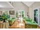 Bright living room with hardwood floors, floral couches, large windows, and view of trees at 81106 Alexander, Chapel Hill, NC 27517