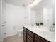 Bright bathroom features a double vanity with a large mirror, neutral walls, and tile flooring at 835 New Derby Ln, Apex, NC 27523