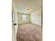 Empty bedroom featuring plush carpeting, neutral walls, white trim and a window providing natural light at 835 New Derby Ln, Apex, NC 27523