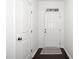 Bright hallway with dark floors, white door, striped rug and transom window at 835 New Derby Ln, Apex, NC 27523