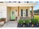 Welcoming front porch with charming wooden columns, a vibrant green door, and stylish landscaping at 84 Elliot Dr Dr, Clayton, NC 27520