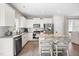 Charming kitchen featuring white cabinets, stainless steel appliances, a granite countertop island, and a breakfast bar with two chairs at 84 Elliot Dr Dr, Clayton, NC 27520