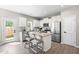 Bright kitchen with a kitchen island, stainless steel appliances, stylish bar chairs and door to the backyard at 84 Elliot Dr Dr, Clayton, NC 27520