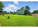 Spacious green backyard with lush lawn, mature trees, and a charming house exterior at 1 Saturn Court Ct, Durham, NC 27703