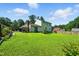 Expansive green backyard with lush lawn, mature trees, and a charming house exterior at 1 Saturn Court Ct, Durham, NC 27703