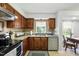Cozy kitchen featuring stainless steel appliances, tile backsplash, and wood cabinets at 1 Saturn Court Ct, Durham, NC 27703