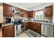 Well-equipped kitchen with stainless steel appliances, granite countertops, and wood cabinetry at 1 Saturn Court Ct, Durham, NC 27703