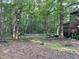 Secluded backyard features a deck, lush trees, and a rustic fence, perfect for outdoor enjoyment and privacy at 1012 King Cir, Chapel Hill, NC 27516