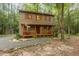 Cozy two-story home with covered front porch nestled in a wooded setting with gravel driveway at 1012 King Cir, Chapel Hill, NC 27516