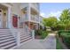 Inviting townhome exterior featuring a charming entrance with a red door, stairs, and a beautiful landscaped walkway at 10330 Sablewood Dr # 104, Raleigh, NC 27617