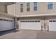Attached garages with white doors and individual unit numbers on a sunny day at 10330 Sablewood Dr # 104, Raleigh, NC 27617