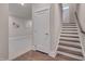 Inviting hallway with stairs, a door, and art leading to a carpeted room at 10330 Sablewood Dr # 104, Raleigh, NC 27617