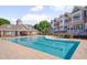 Large community pool surrounded by lounge chairs and residential buildings on a sunny day at 10330 Sablewood Dr # 104, Raleigh, NC 27617