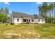 White farmhouse exterior with a large yard and covered patio at 1050 Southern High School Rd, Burlington, NC 27215