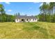 White farmhouse exterior with a large yard and covered patio at 1050 Southern High School Rd, Burlington, NC 27215