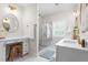 Bright bathroom featuring a vanity with makeup mirror, glass enclosed shower, and white marble countertops and flooring at 1050 Southern High School Rd, Burlington, NC 27215