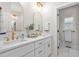 Bright bathroom featuring dual sinks, white cabinets, gold fixtures, and neutral finishes at 1050 Southern High School Rd, Burlington, NC 27215