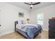 Comfortable bedroom with luxury vinyl floors, ceiling fan, shuttered window, and queen-size bed with blue bedding at 1050 Southern High School Rd, Burlington, NC 27215