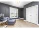 Stylish bonus room featuring luxury vinyl floors, a gray sofa, wainscotting, and a big window at 1050 Southern High School Rd, Burlington, NC 27215