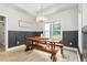 Charming dining area featuring wainscoting detail, modern light fixture, and rustic wooden table at 1050 Southern High School Rd, Burlington, NC 27215