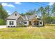 Charming exterior featuring stone accents, a covered porch, and manicured landscaping at 1050 Southern High School Rd, Burlington, NC 27215