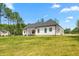 A modern farmhouse exterior with white siding, a dark roof, and a spacious lawn at 1050 Southern High School Rd, Burlington, NC 27215
