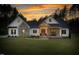 Charming home featuring stone accents, a welcoming front porch and bench, against a sunset at 1050 Southern High School Rd, Burlington, NC 27215