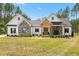 Charming home featuring stone accents, a welcoming front porch, and a well-manicured lawn at 1050 Southern High School Rd, Burlington, NC 27215