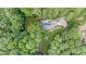 An aerial view of a home nestled among trees with a backyard deck and long driveway at 106 Autumn Cir, Cary, NC 27518