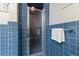 Blue-tiled shower with a glass door, featuring a clean design and an attached towel rack at 106 Autumn Cir, Cary, NC 27518