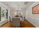 Inviting dining room with hardwood floors, chandelier, and natural light from large windows at 106 Autumn Cir, Cary, NC 27518