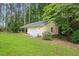Detached garage with a lush, green lawn, surrounded by mature trees providing a serene and private setting at 106 Autumn Cir, Cary, NC 27518
