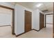 Hallway with neutral carpet, multiple closets and doors with wood trim at 106 Autumn Cir, Cary, NC 27518